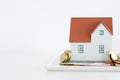 House ownership concept Ã¢â¬â a model house on a pile of coins Royalty Free Stock Photo